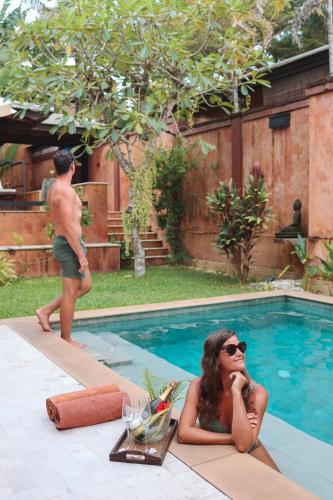 a woman laying on the ground next to a swimming pool at Alanta Pool Villa in Ko Lanta
