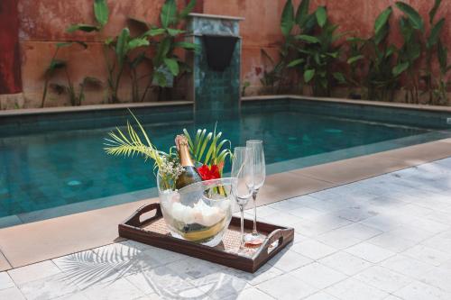 a tray with two wine glasses and a bowl of fish at Alanta Pool Villa in Ko Lanta
