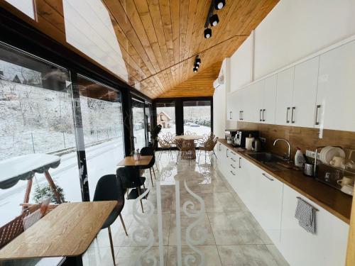 uma cozinha com armários brancos e um tecto de madeira em Willa FOLK Pieniny em Szczawnica