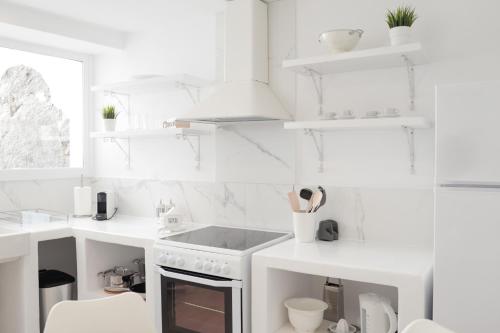 a white kitchen with white counters and a sink at Elegant white in the heart of Ioulida on the island of Kea in Ioulida