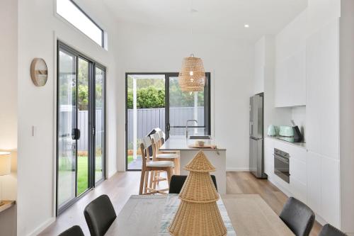 a kitchen and dining room with a table and chairs at Saoire - Pet Friendly - 5 Mins Walk to Beach in Culburra Beach