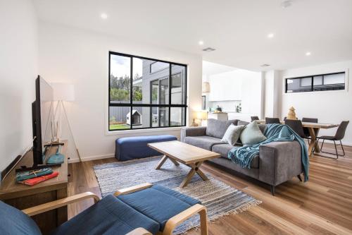 a living room with a couch and a table at Saoire - Pet Friendly - 5 Mins Walk to Beach in Culburra Beach