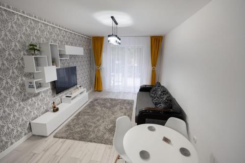 a living room with a couch and a tv at White DeLuxe Apartment in Ploieşti