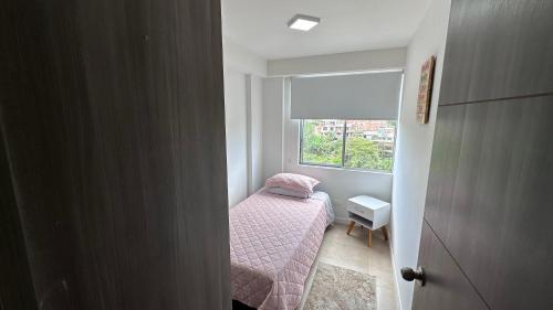 a small bedroom with a small bed and a window at Pearl 23 in Pereira