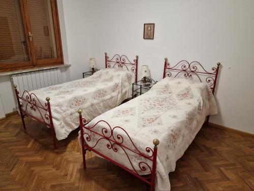 Habitat - Casa Vacanze Perugia في بيروجيا: سريرين يجلسون بجانب بعض في غرفة