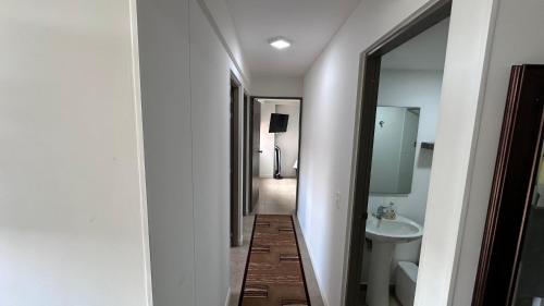 a bathroom with a sink and a toilet and a mirror at Pearl 23 in Pereira