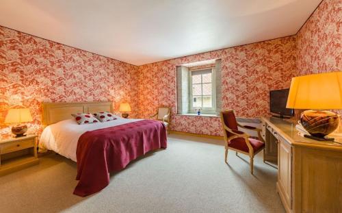 Dormitorio con cama, escritorio y TV en Château de Bournel en Cubry