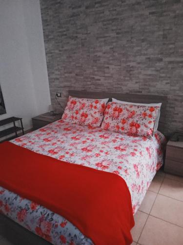um quarto com uma cama com um edredão vermelho e branco em La Corte di Ma.Mi. em Gallarate