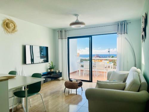 sala de estar con sofá y vistas al océano en Fantastic sea and golf course view house with 3 bedrooms en San Miguel de Abona