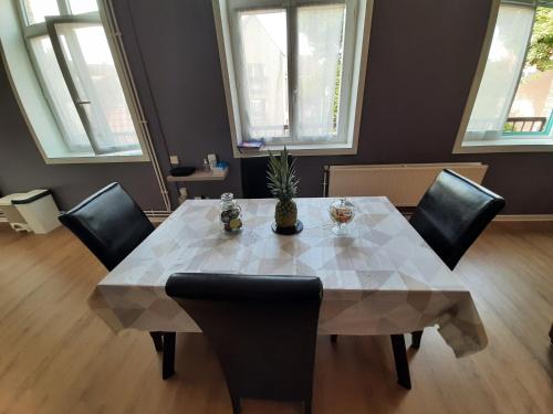 une table à manger avec des chaises noires et une table en marbre blanc dans l'établissement GDK locations meublés GRAVELINES, à Gravelines