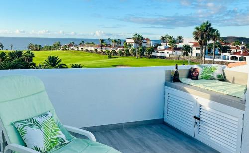 Un balcón con una silla y vistas al océano. en Fantastic sea and golf course view house with 3 bedrooms en San Miguel de Abona