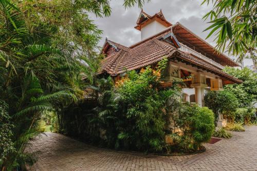 a house with a tiled roof on a brick road at Aadisaktthi Leisure Resort, Kovalam in Trivandrum