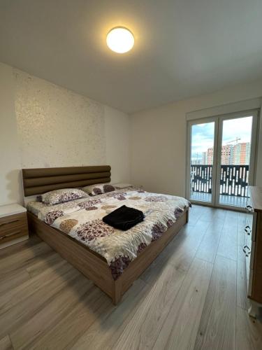 a bedroom with a bed and a large window at 4-YOU Apartment in Ferizaj