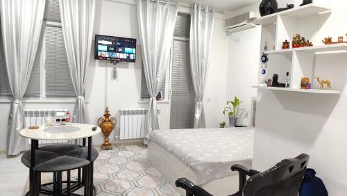 a bedroom with a bed and a table and chairs at parkent plaza apartments in Tashkent