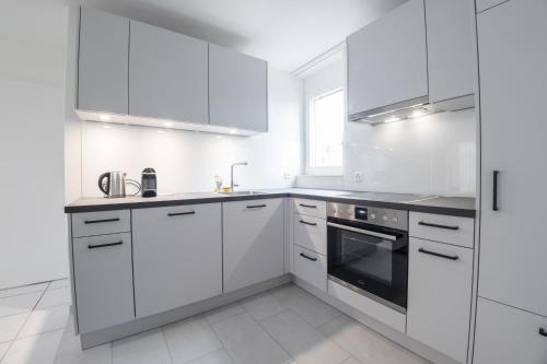 3.5 Room Apartment في Würenlos: مطبخ أبيض مع دواليب بيضاء ومغسلة