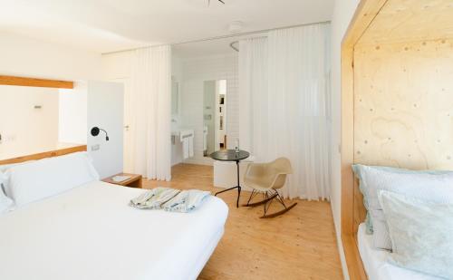 Dormitorio blanco con cama y mesa en Hotel Aire de Bardenas, en Tudela