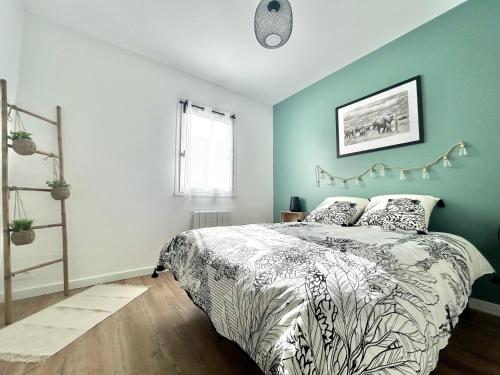 a bedroom with a bed and a blue wall at L'échappée Cabourgeaise in Cabourg