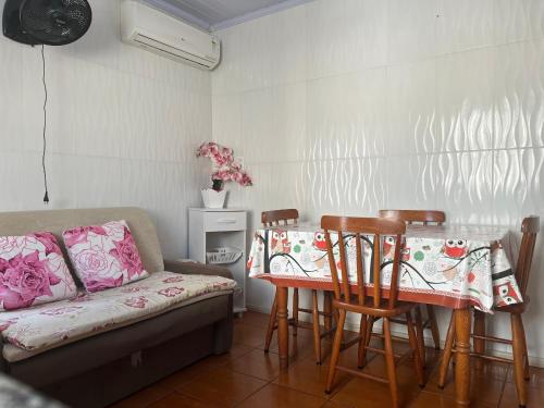 a living room with a couch and a table and chairs at Edícula aconchegante 100m do Mar in Sombrio