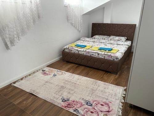 a small bedroom with a bed and a rug at SA Apartment in Gjilan