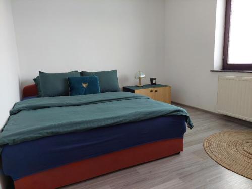 a bedroom with a large bed with blue pillows at Apartmani Marin in Kupres