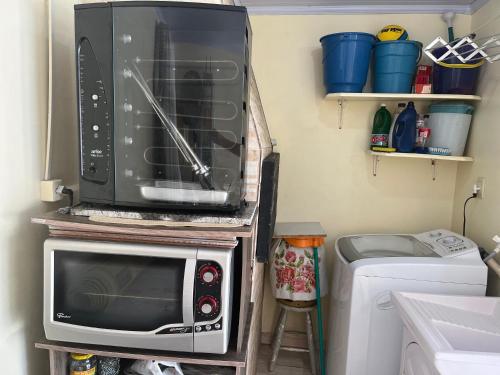 a microwave oven sitting on top of a stove at Edícula aconchegante 100m do Mar in Sombrio