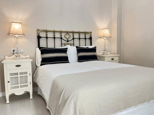 een witte slaapkamer met een groot bed en 2 nachtkastjes bij Magnifico Alojamiento Con Encanto En El Centro in Santander