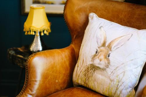 a pillow with a rabbit on it sitting on a chair at 1863 Restaurant with Rooms in Pooley Bridge