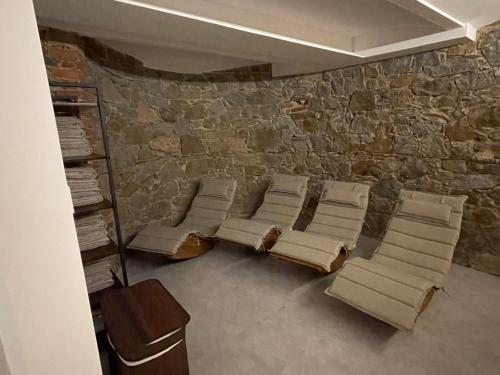 a room with chairs and a stone wall at Waldhaus Pulsnitz in Pulsnitz