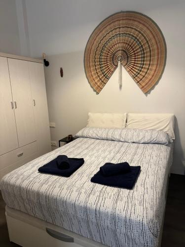 Apartamento Centro Histórico Málaga في مالقة: غرفة نوم بسرير وفوط سوداء عليها
