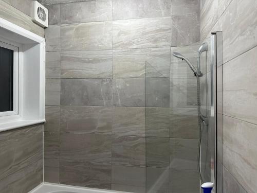 a shower with a glass door in a bathroom at Double Room With Free WiFi Keedonwood Road in Bromley
