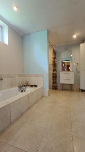 a large bathroom with a tub and a sink at Dom na szlaku Krakowskim in Łączany