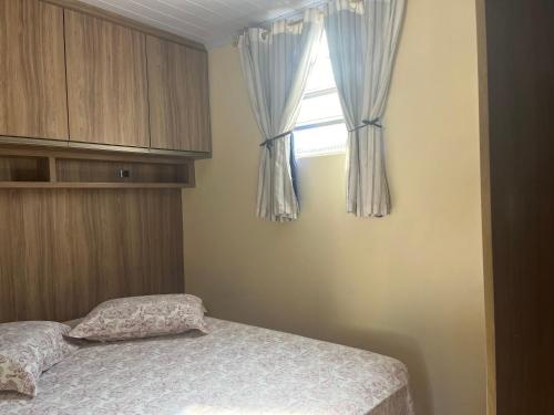 a bedroom with a bed and a window at Edícula aconchegante 100m do Mar in Sombrio