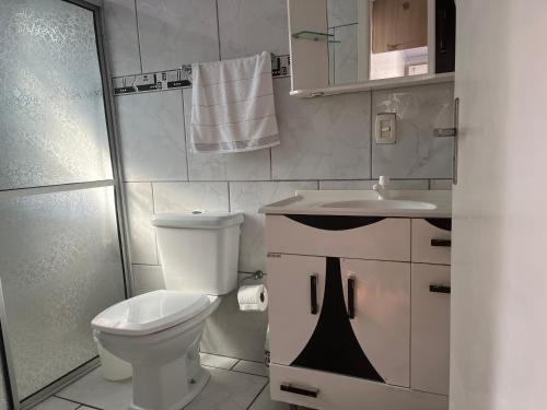 La salle de bains est pourvue de toilettes, d'un lavabo et d'une douche. dans l'établissement Edícula aconchegante 100m do Mar, à Sombrio