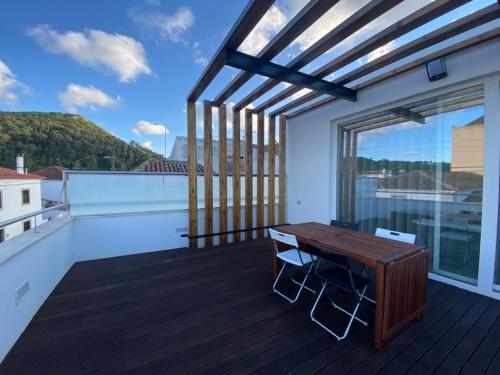 a balcony with a wooden table and a view at Moradia com jaccuzzi e sky view in Bombarral