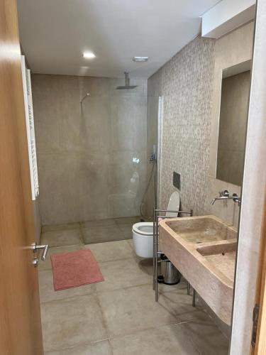 a bathroom with a tub and a sink and a toilet at Moradia com jaccuzzi e sky view in Bombarral