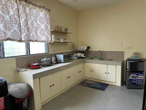 a kitchen with white cabinets and a sink and a window at Cozy Apartment near beach in San Fernando