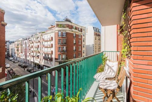 einen Balkon mit einer Bank und einige Gebäude in der Unterkunft 10 mns from Champs-Elysées, quiet in Paris