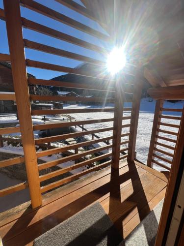 a sun shines through a wooden railing on a deck at De Goldene Traum in Gressoney-Saint-Jean