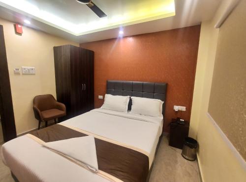 a hotel room with a bed and a chair at Royal View Residency in Bodh Gaya