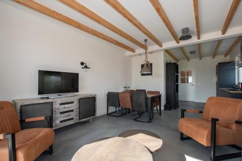a living room with a television and a table at Christinahoeve Logies in Boskoop