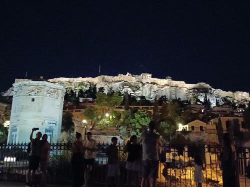 eine Gruppe von Menschen, die nachts vor einem Berg stehen in der Unterkunft Mary cozy house in Athen