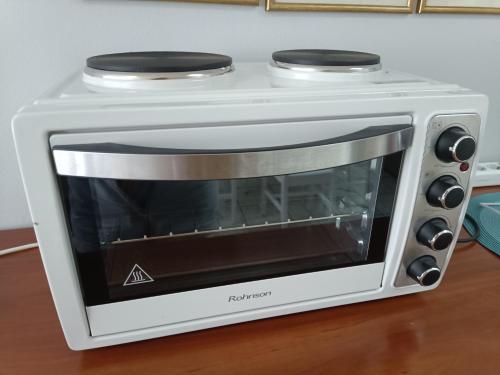 a white toaster oven sitting on top of a table at Mary cozy house in Athens