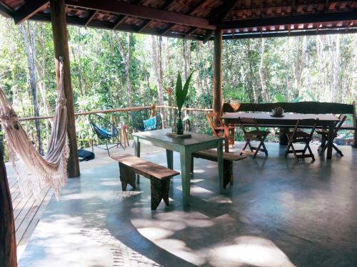 a patio with a table and benches on a deck at YbYmara Eco Glamping in Serra Grande