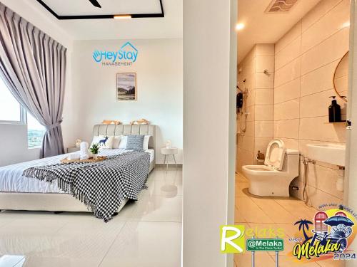 a bedroom with a bed and a bathroom with a toilet at Amber Cove Impression City By Heystay Management in Melaka