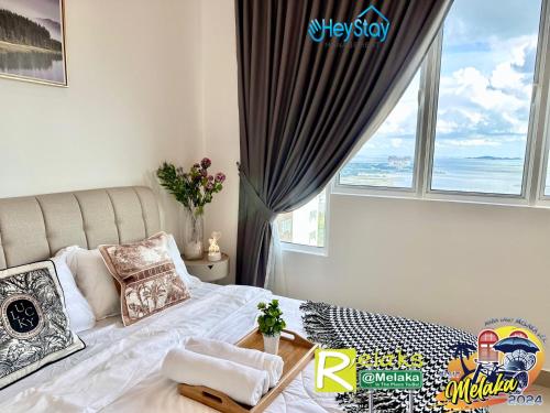 a bedroom with a bed with a large window at Amber Cove Impression City By Heystay Management in Melaka