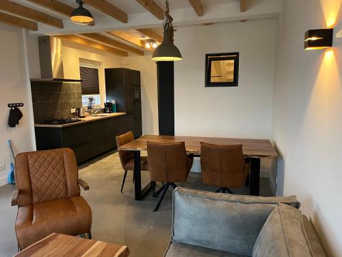 cocina y comedor con mesa de madera y sillas en Christinahoeve Logies en Boskoop