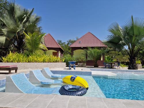 a pool with two chairs and a yellow tube in the middle at Asamai Villas in Sifoe