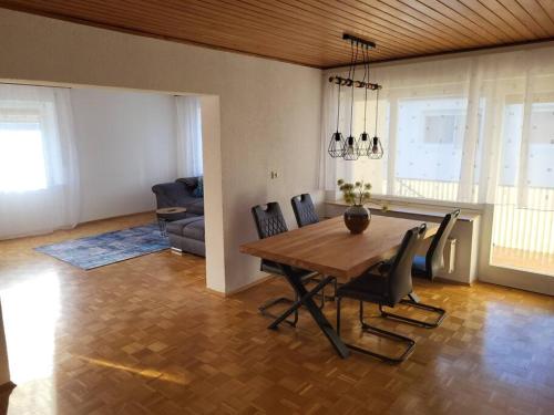 uma sala de estar com uma mesa de madeira e cadeiras em Zentrale, Helle Ferienwohnung em Crailsheim