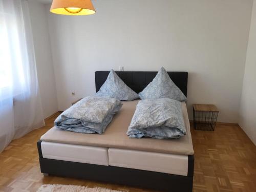 uma cama com almofadas num quarto em Zentrale, Helle Ferienwohnung em Crailsheim