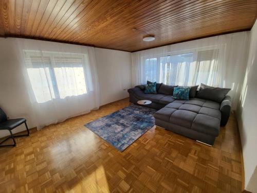 a living room with a couch and a wooden ceiling at Zentrale, Helle Ferienwohnung in Crailsheim